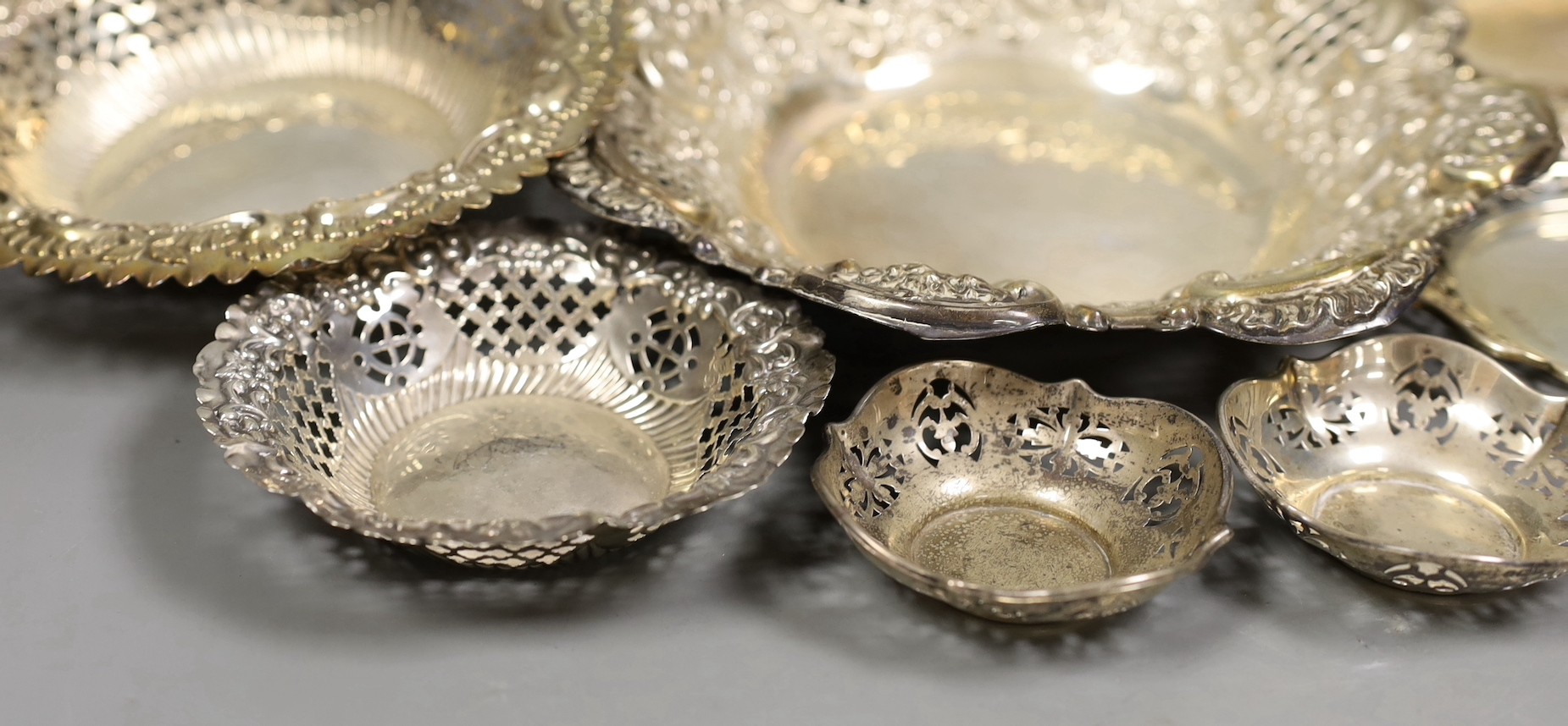 Seven assorted Victorian and later pierced silver nut or bonbon dishes, largest 22.6cm in diameter, 19.4oz.